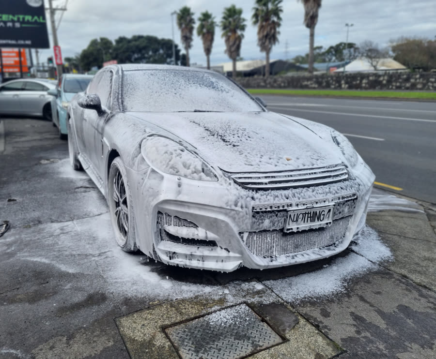 Snow foam pre-wash covering a vehicle before hand washing