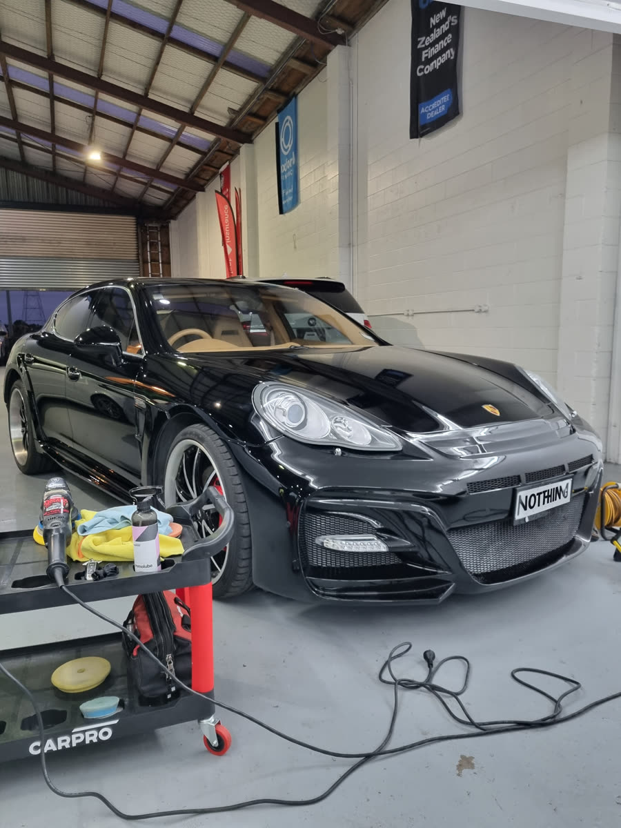 Detailing equipment and products set up beside a vehicle